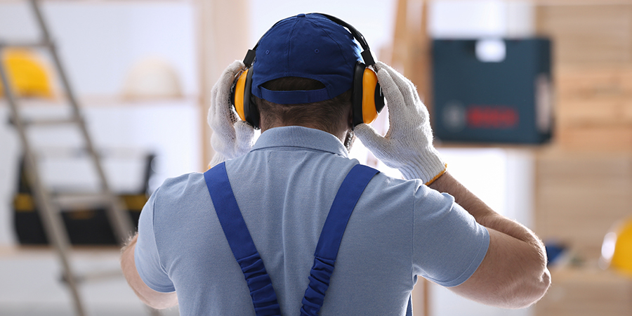 Ein Bauarbeiter trägt einen Lärmschutz